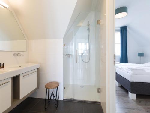a bathroom with a shower and a sink and a bed at Friesland Villa with Fireplace in Delfstrahuizen