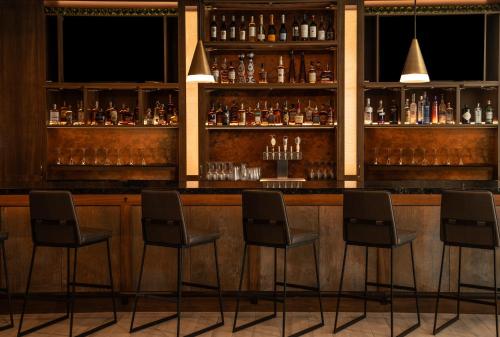 a bar with four chairs in front of it at Home2 Suites by Hilton Fort Walton Beach Eglin AirForce Base in Fort Walton Beach