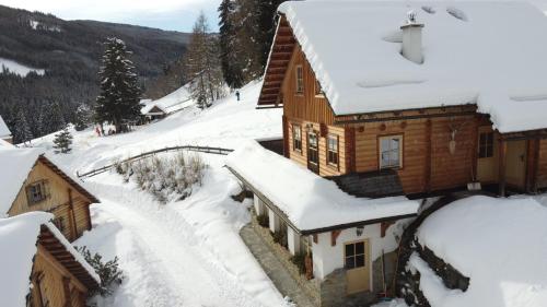 a house covered in snow in a mountain at Hüttendorf Schlögelberger in Sankt Margarethen im Lungau