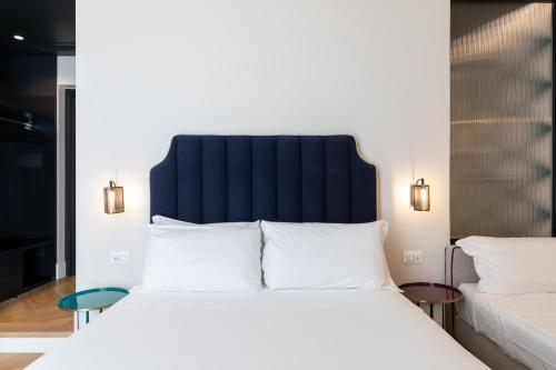 a bedroom with a large white bed with a black headboard at Relais Ammira in Naples