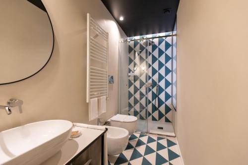 a bathroom with a sink and a toilet and a shower at Relais Ammira in Naples