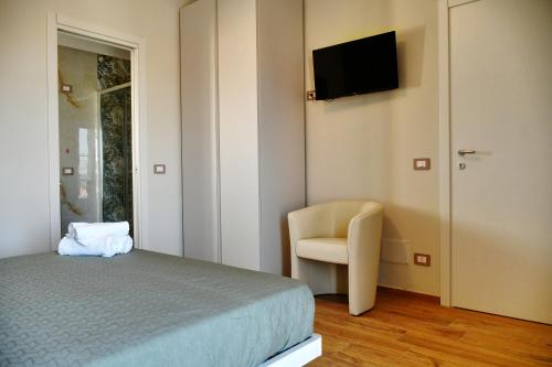 a bedroom with a bed and a chair and a television at Dimora il Tartufo Relax e Benessere con Spa Privata in Busso