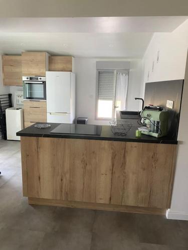 une cuisine avec un grand îlot au milieu dans l'établissement La Mignardise, à Mignavillers