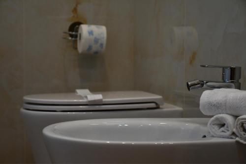 a bathroom with a toilet and a sink with towels at Dimora il Tartufo Relax e Benessere con Spa Privata in Busso