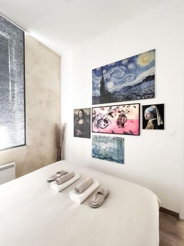 un lit blanc avec deux paires de chaussures dessus dans l'établissement Le Petit Cocon - Pause douceur, à Cambrai