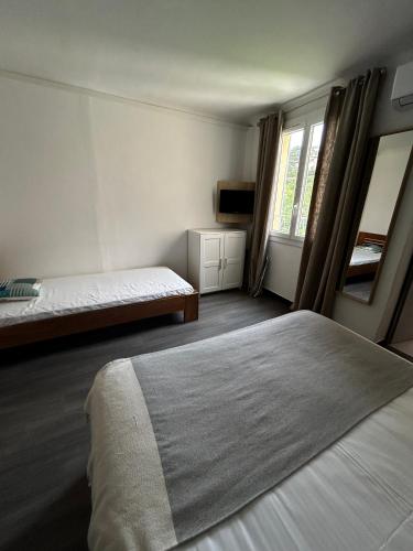 a small bedroom with two beds and a window at Hôtel La Petite Bohème in Le Lavandou