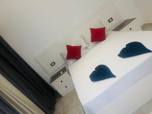 a bed with three blue and red pillows on it at Swiss Royal DAHAB in Dahab