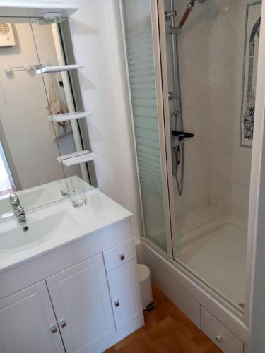 une salle de bain blanche avec une douche et un lavabo dans l'établissement Capri Bali B36, Superbe vue mer, parking, clim, au Cap d'Agde