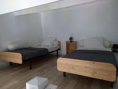 - une chambre avec 2 lits et un mur blanc dans l'établissement Capri Bali B36, Superbe vue mer, parking, clim, au Cap d'Agde