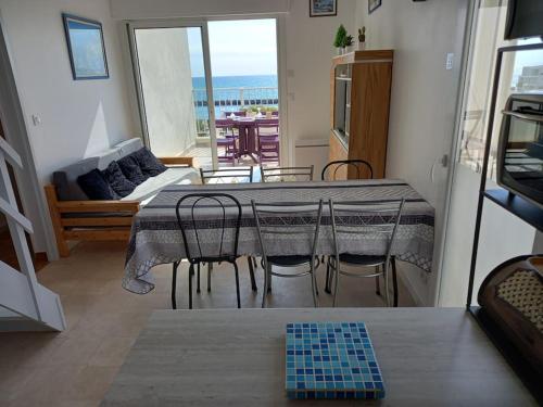 un salon avec une table, des chaises et un canapé dans l'établissement Capri Bali B36, Superbe vue mer, parking, clim, au Cap d'Agde