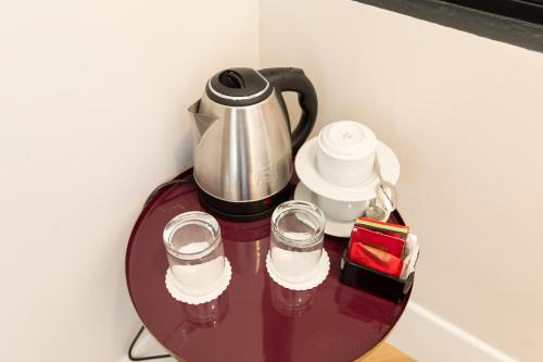 a table with a coffee pot and glasses on it at Relais Ammira in Naples
