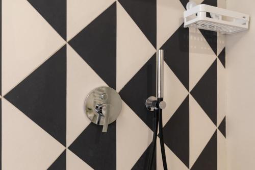 a bathroom with a black and white checkered wall at Relais Ammira in Naples