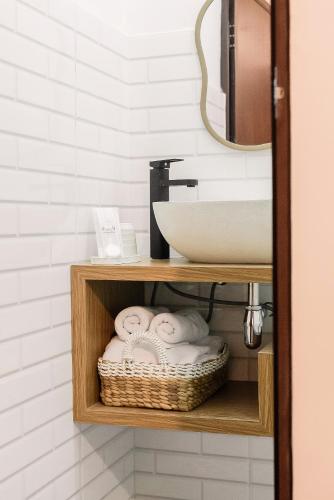 a bathroom with a sink and a shelf with towels at Sukhayana Stay Malioboro in Yogyakarta
