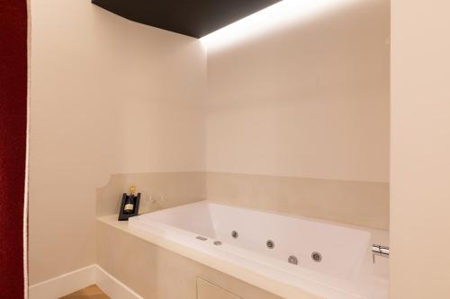 a white bath tub in a bathroom with a black ceiling at Relais Ammira in Naples