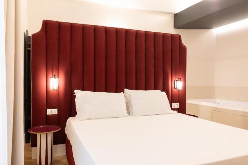 a bedroom with a large bed with a red headboard at Relais Ammira in Naples
