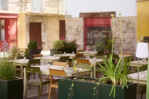 a restaurant with tables and chairs and potted plants at Hôtel Restaurant Le Botaniste in Prats-de-Mollo-la-Preste