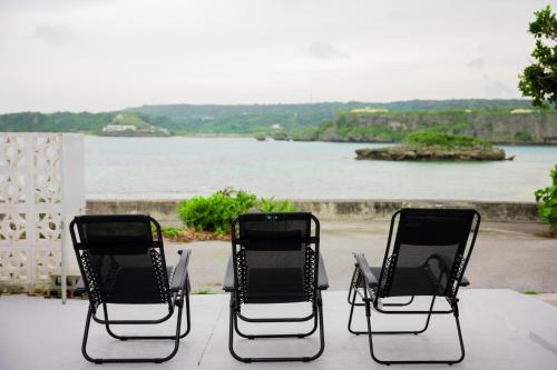 two chairs on a patio with a view of the water at ASAHi in Ikei