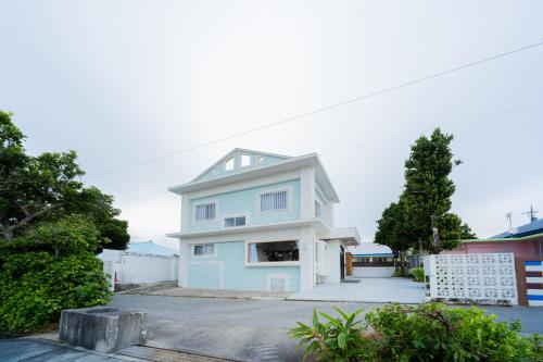 a blue and white house with a fence at ASAHi in Ikei