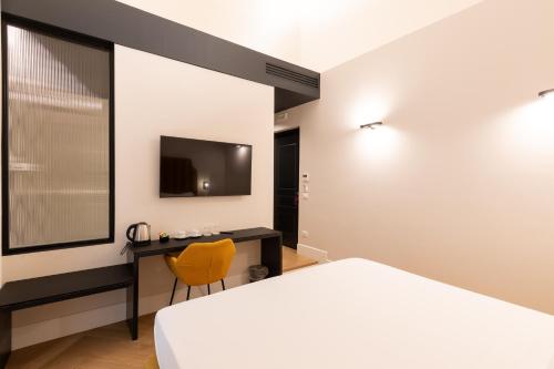 a bedroom with a bed and a desk and a television at Relais Ammira in Naples