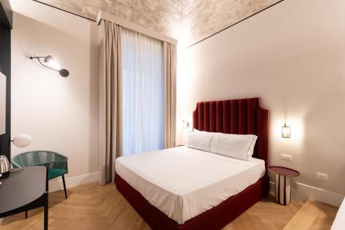 a bedroom with a bed with a red headboard at Relais Ammira in Naples