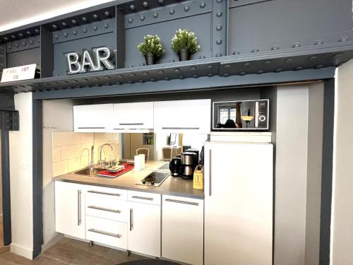 une cuisine avec des armoires blanches et un réfrigérateur blanc dans l'établissement Central & functional apartment at Châtelet, à Paris