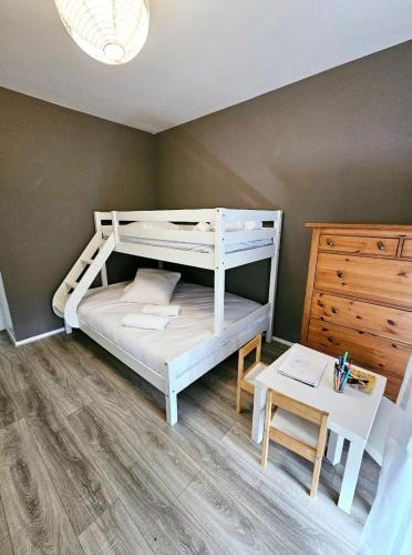 une chambre avec un lit superposé et une table dans l'établissement Appartement avec parking privé, à Boussy-Saint-Antoine