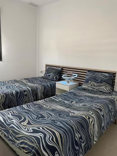 two beds sitting next to each other in a room at Casa Diana Golf in Murcia