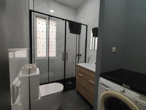 łazienka z toaletą i pralką w obiekcie Apartment la paz w Madrycie