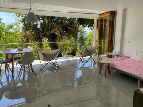 a living room with a balcony with a table and chairs at Green Villa Sambirenteng in Gretek
