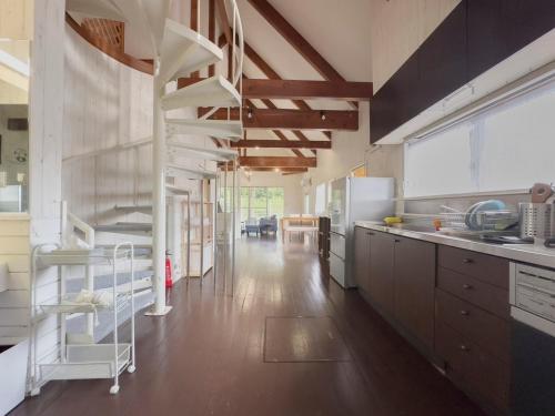 a kitchen with a spiral staircase in the middle at プライベートサウナ アザミガーデン大竹 in Tomota