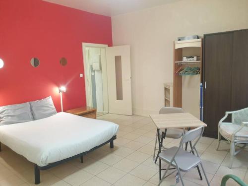 une chambre avec un lit, une table et des chaises dans l'établissement Au Bonheur des dames, à Laval