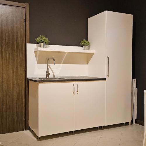 a kitchen with a sink and a white refrigerator at San Donato Policlinico BBking in San Donato Milanese