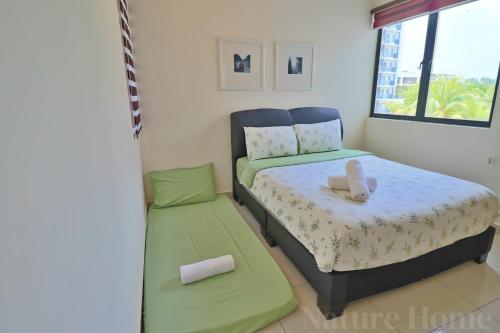 a small bedroom with a bed and a window at Nature Home 2 - Swiss Garden Resort Residences Beachfront Villa in Kuantan