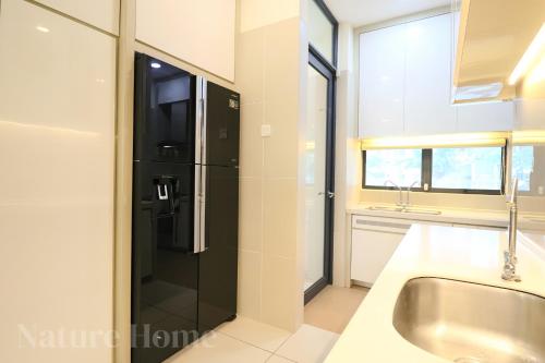 a bathroom with a sink and a black refrigerator at Nature Home 2 - Swiss Garden Resort Residences Beachfront Villa in Kuantan