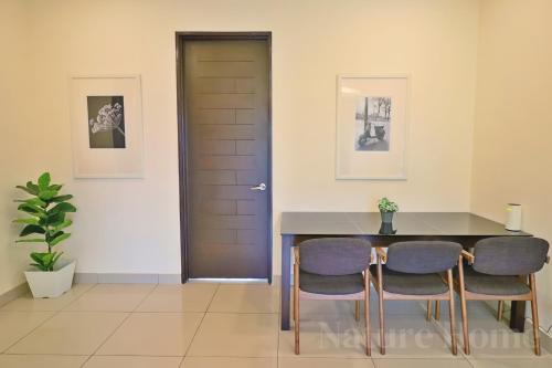 a dining room with a table and chairs and a door at Nature Home 2 - Swiss Garden Resort Residences Beachfront Villa in Kuantan