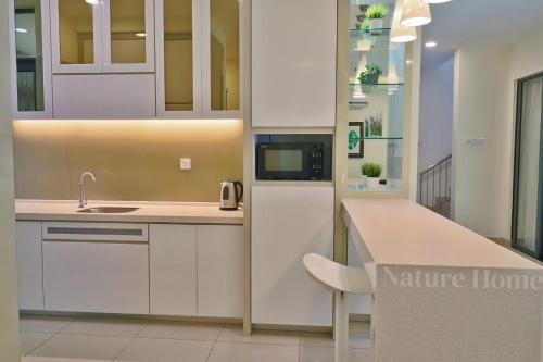 a kitchen with white cabinets and a counter top at Nature Home 2 - Swiss Garden Resort Residences Beachfront Villa in Kuantan