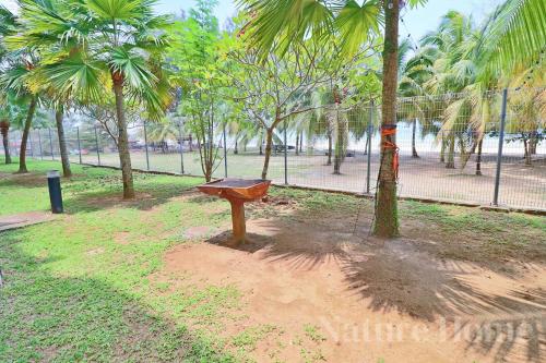 a bench in a park with palm trees at Nature Home 2 - Swiss Garden Resort Residences Beachfront Villa in Kuantan
