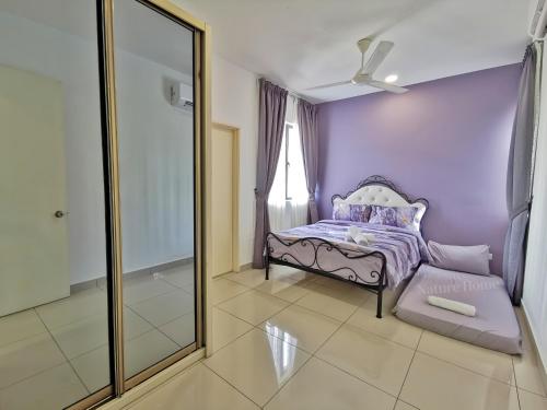 a purple bedroom with a bed and a mirror at Nature Home 2 - Swiss Garden Resort Residences Beachfront Villa in Kuantan
