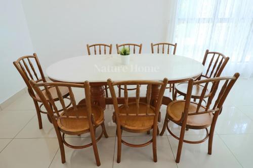 a dining room table and chairs with a white table at Nature Home 2 - Swiss Garden Resort Residences Beachfront Villa in Kuantan