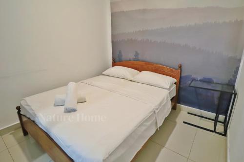 a small bedroom with a bed with white sheets at Nature Home 2 - Swiss Garden Resort Residences Beachfront Villa in Kuantan