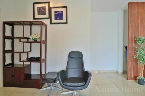 a chair sitting in a living room with a shelf at Nature Home 2 - Swiss Garden Resort Residences Beachfront Villa in Kuantan