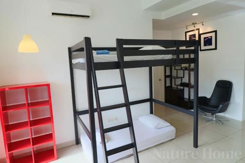 a bunk bed in a room with a desk and a chair at Nature Home 2 - Swiss Garden Resort Residences Beachfront Villa in Kuantan