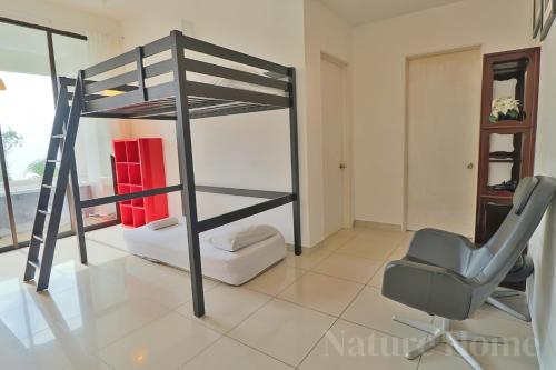 a bedroom with a bunk bed and a chair at Nature Home 2 - Swiss Garden Resort Residences Beachfront Villa in Kuantan