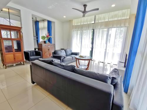 a living room with a couch and a table at Nature Home 2 - Swiss Garden Resort Residences Beachfront Villa in Kuantan