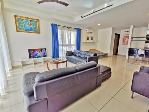 a living room with a couch and a table at Nature Home 2 - Swiss Garden Resort Residences Beachfront Villa in Kuantan