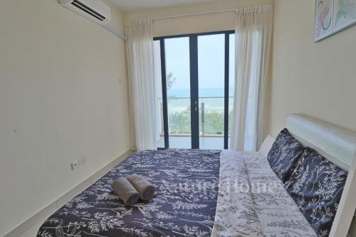 a bedroom with a bed with a large window at Nature Home 2 - Swiss Garden Resort Residences Beachfront Villa in Kuantan
