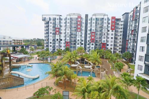 an apartment complex with a swimming pool and palm trees at Nature Home 2 - Swiss Garden Resort Residences Beachfront Villa in Kuantan