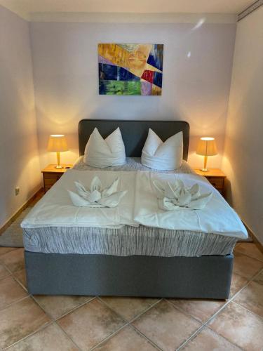 a bedroom with a bed with white sheets and pillows at Ferienhaus Beyer in Kühlungsborn