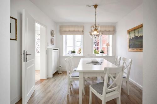 Un comedor blanco con una mesa y sillas blancas. en Villa Maiken, en Wyk auf Föhr