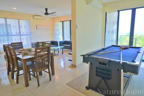 a living room with a ping pong table and a dining room at Nature Home - Swiss Garden Resort Residences in Kuantan